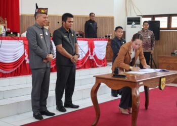 Wakil Ketua I DPRD Gumas Nomi Aprilia, disaksikan Bupati Jaya S Monong, Ketua DPRD Binartha, Wakil Ketua II Espriadi, dan lainnya saat menandatangani nota kesepakatan bersama saat rapat paripurna di Kuala Kurun. (IST)