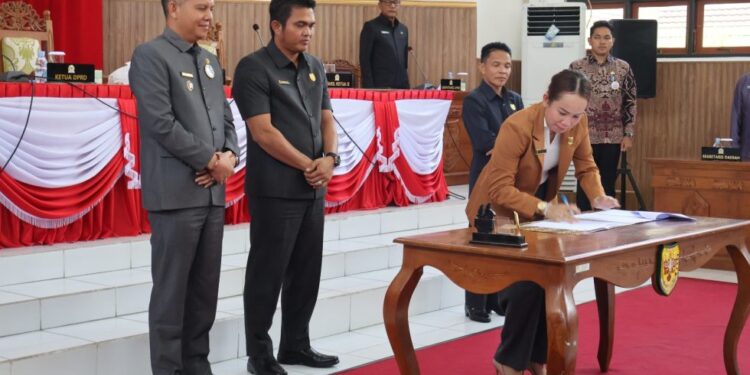 Wakil Ketua I DPRD Gumas Nomi Aprilia, disaksikan Bupati Jaya S Monong, Ketua DPRD Binartha, Wakil Ketua II Espriadi, dan lainnya saat menandatangani nota kesepakatan bersama saat rapat paripurna di Kuala Kurun. (IST)