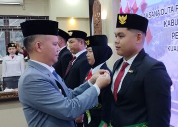 Bupati Gumas Jaya S Monong menyematkan pin kepada Ketua DPPI kabupaten 2025-2029 Mikhael Rovando Tobyas di Kuala Kurun, Senin (14/7/2025). (Foto : Diskominfosantik Gunung Mas)