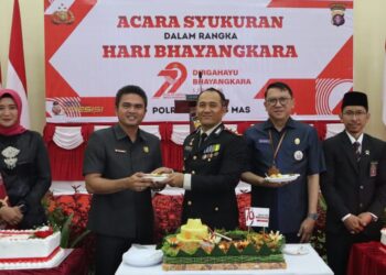 Kapolres Gumas AKBP Heru Eko Wibowo menyerahkan potongan tumpeng kepada Ketua DPRD Binartha saat Hari Bhayangkara ke-79 di Kuala Kurun, Selasa (1/7/2025). (IST)