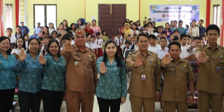 Kepala DPKP Gumas Eigh Manto, Camat Rungan Penyang Massal, Ketua TP PKK Mimie Mariatie Jaya S Monong, peserta kampanye Gemarikan, dan lainnya berfoto bersama di Desa Tumbang Jutuh Kecamatan Rungan, Selasa (15/7/2025). (Foto : Diskominfosantik Gumas)