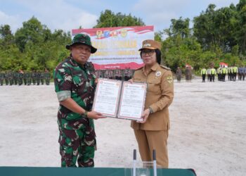 Wabup Gumas Efrensia LP Umbing dan Pabung Gunung Mas Kodim 1016/Plk Letkol Inf Mahsun Abadi, S.Ag. menunjukkan naskah program TMMD Imbangan Ke-125 di Desa Karya Bhakti, Kecamatan Rungan, Rabu (23/7/2025). (IST)
