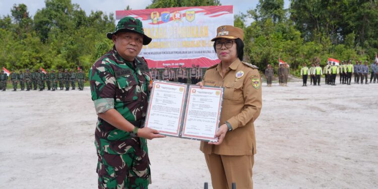 Wabup Gumas Efrensia LP Umbing dan Pabung Gunung Mas Kodim 1016/Plk Letkol Inf Mahsun Abadi, S.Ag. menunjukkan naskah program TMMD Imbangan Ke-125 di Desa Karya Bhakti, Kecamatan Rungan, Rabu (23/7/2025). (IST)