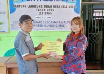Perangkat Desa Karta Bhakti Kecamatan Rungan (kanan) menyalurkan BLT Desa kepada salah satu KPM di desa setempat, Juni 2025. (Foto : Pemerintah Desa Karya Bhakti)