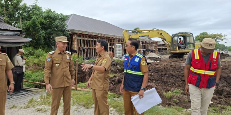 Bupati Gumas Jaya S Monong didampingi Kepala DPU Baryen dan jajaran saat meninjau pengerjaan drainase di Jalan Sudirman Kelurahan Tampang Tumbang Anjir, Kecamatan Kurun, Senin (14/7/2025). (IST)
