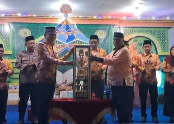 Sekda Gumas Richard (kiri) menerima piala bergilir dari Camat Rungan Penyang untuk diperebutkan kembali, saat pembukaan MTQ XVIII tingkat kabupaten di Kelurahan Tewah Kecamatan Tewah, Senin malam (4/8/2025). (IST)